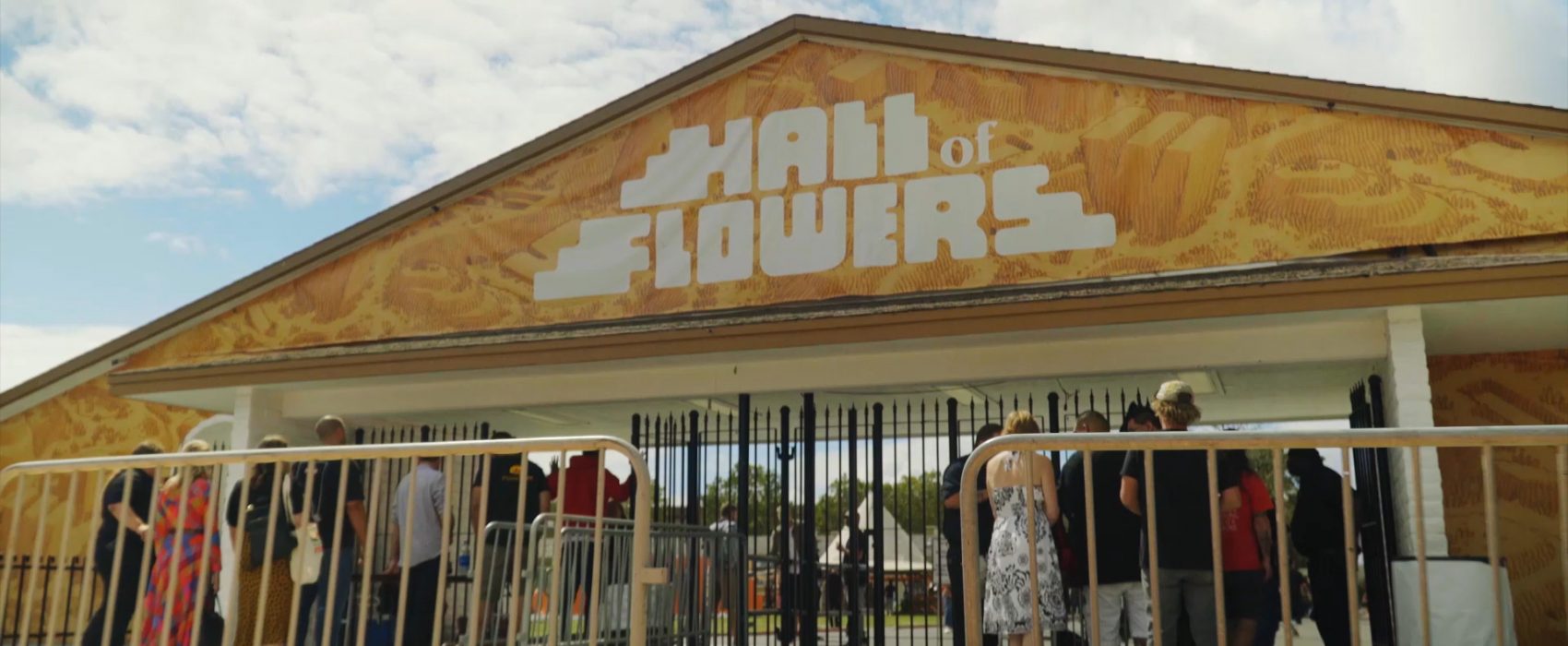 Yellow roof top with a sign reading, "Hall of Flowers"