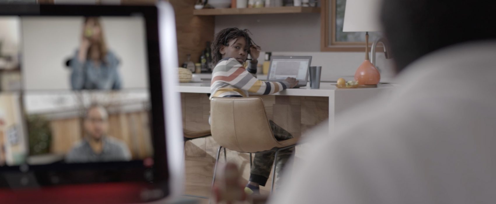 Virtual meeting with child in the background on a laptop computer